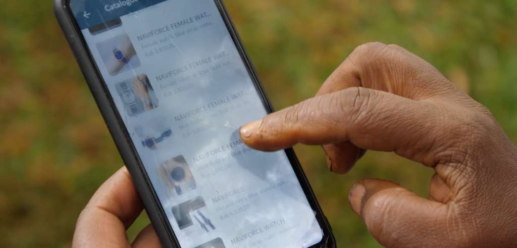 Kenyansk kvinna scrollar på smartphone